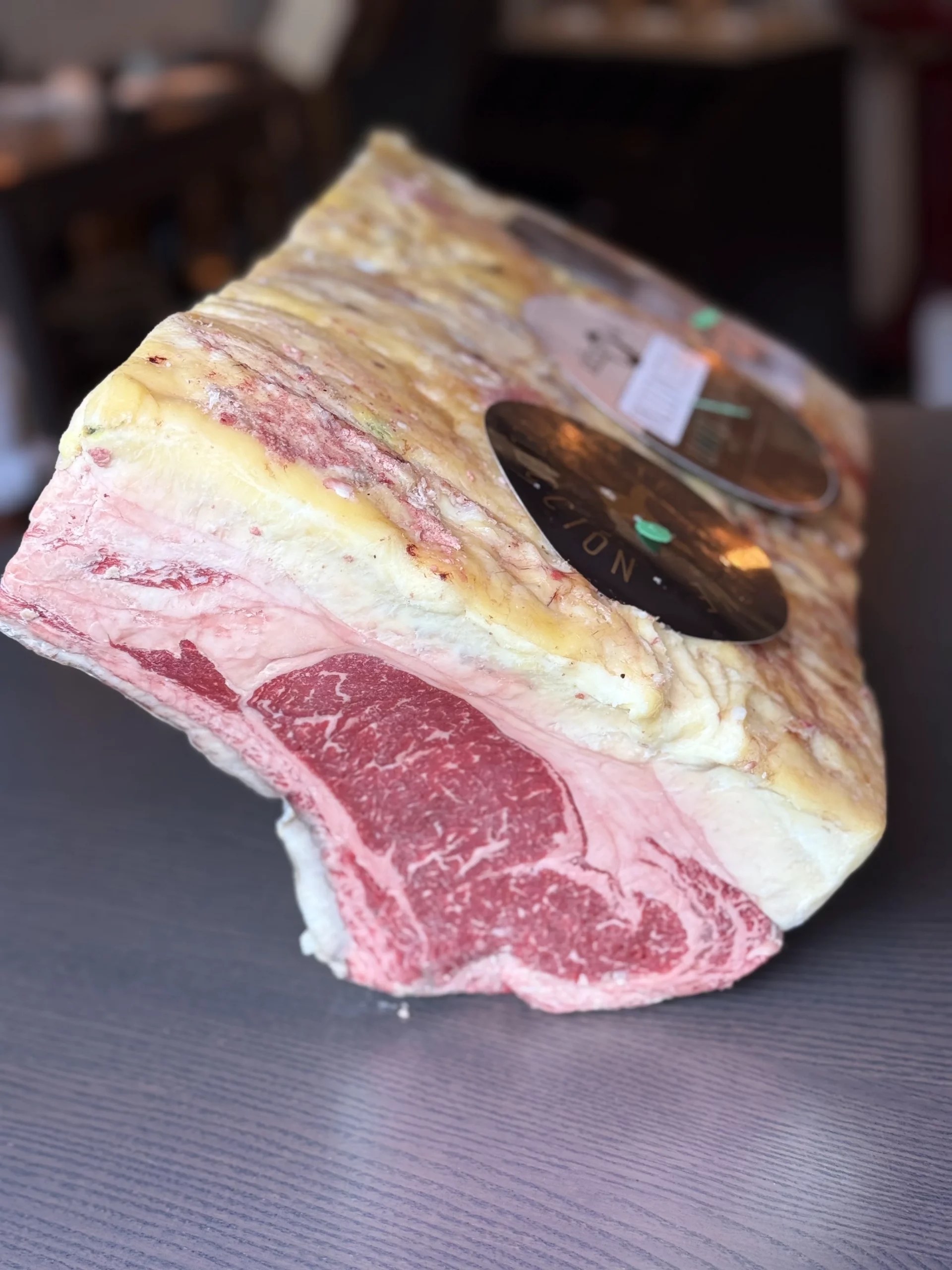Pièce de bœuf crue fortement persillée sous vide, avec une épaisse couche de gras et des étiquettes visibles