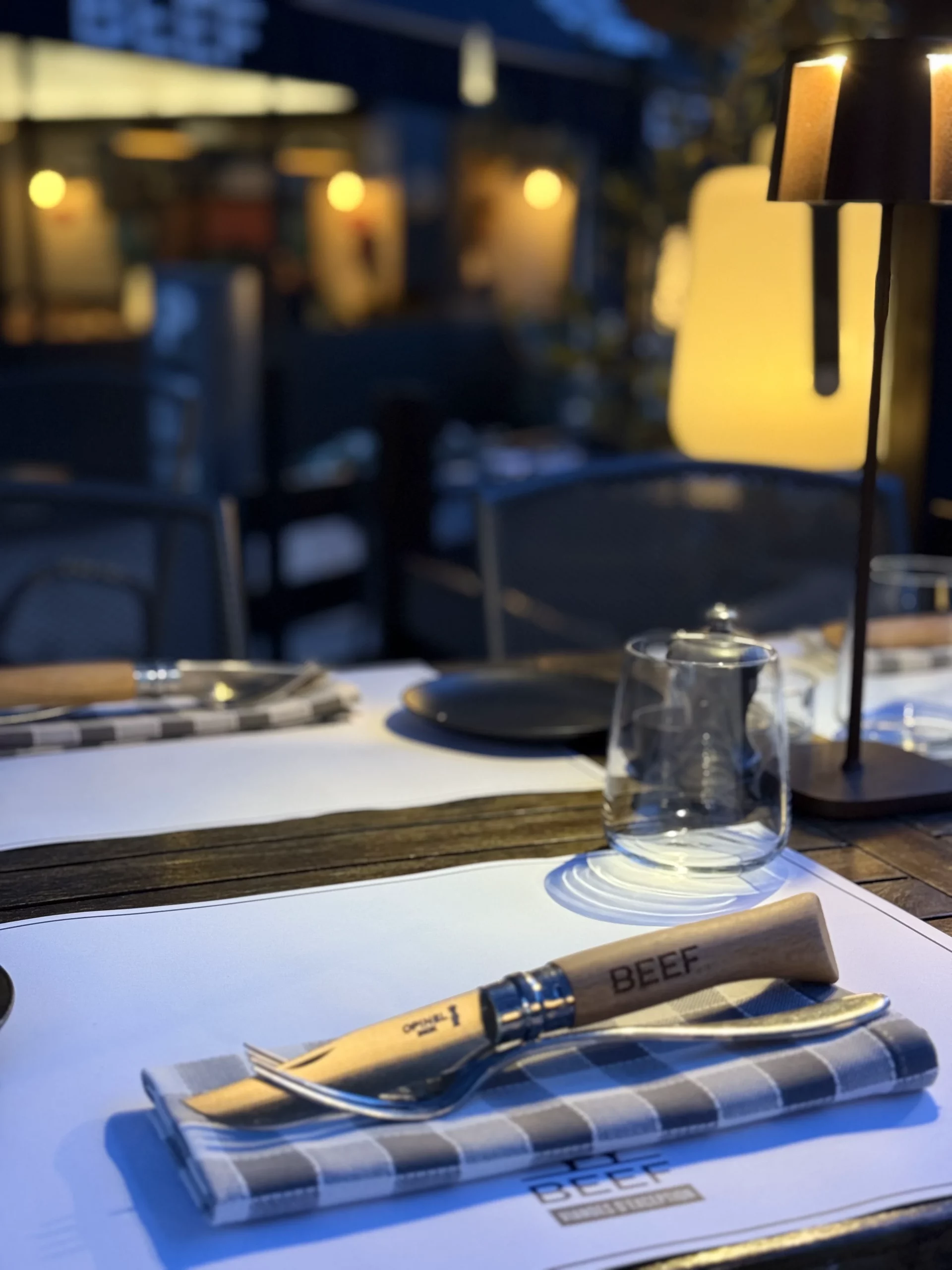 Table dressée dans un restaurant à Genève avec menu, couverts et lumière chaleureuse